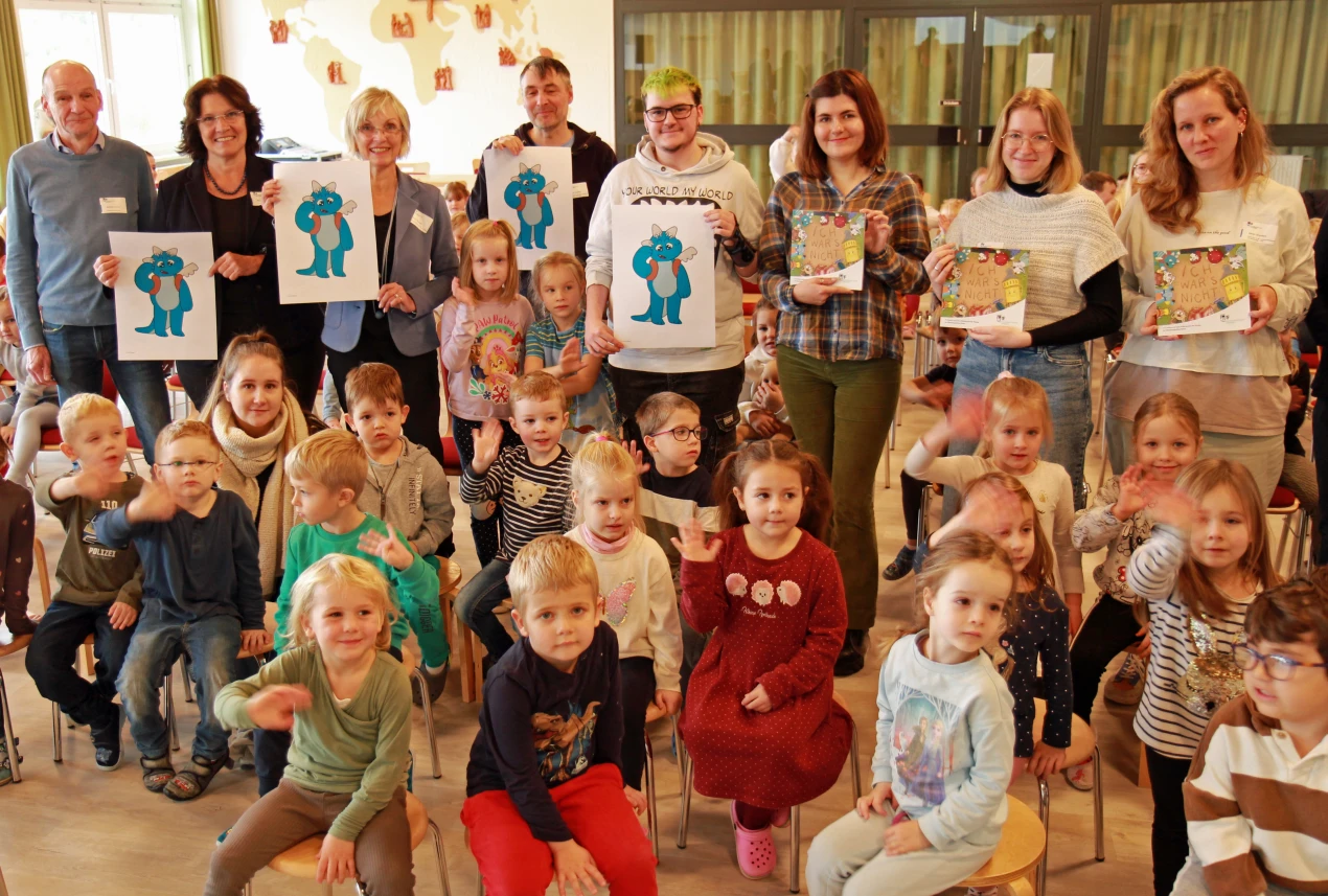 Der blaue Drache Pino wurde von den Kindern im Evangelischen Familienzentrum Marienheide-Müllenbach begeistert empfangen. Das Bildungsbüro Oberberg stellte gemeinsam mit der ecosign/Akamdemie für gestaltung in Köln präsentierten das neue (Vor-)Lesemaskottchen und das Comicheft (v.l.n.r.): Norbert Fischer, päd. Mitarbeiter des Bildungsbüro Oberberg; Birgit Steuer, Leitung Bildungsbüro; Anke Koester, Leiterin des Amtes für Schule und Bildung; Leo Leowald, Dozent an der ecosign; Colin Biltgen; Emilia Senotroussova, Linda Glaser und Sarah Brunßen, Studierende an der ecosign-Akademie.  (Foto: OBK)