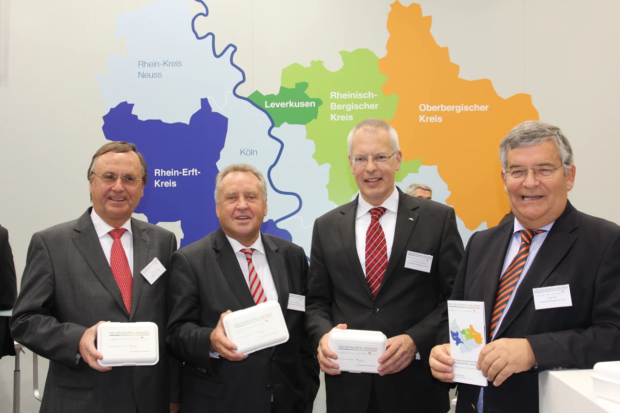 Die Repräsentanten des Gemeinschaftsstandes mit einer Brotdose „Der Speckgürtel von Köln“ in den Händen, die passend zum Messe-Auftritt mit Mäusespeck gefüllt ist und an interessierte Immobilien-Entwickler und -Investoren ausgegeben wird. V.l.: Landrat Werner Stump (Rhein-Erft-Kreis), Oberbürgermeister Reinhard Buchhorn (Stadt Leverkusen), Landrat Dr. Hermann-Josef Tebroke (Rheinisch-Bergischer Kreis) und Landrat Hagen Jobi (Oberbergischer Kreis) (Foto: Region Köln/Bonn e.V.)