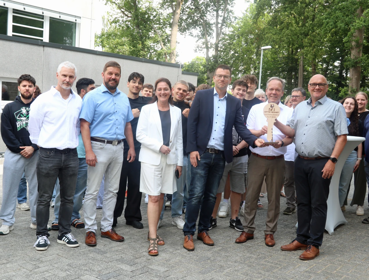 Der Oberbergische Kreis ist Bauträger der neuen Sporthalle am Kaufmännischen Berufskolleg am Standort Waldbröl. Landrat Klaus Grootens (2. v. r.) reicht den symbolischen Schlüssel von Oliver Schierz; Firma Quast/ Siegen (3. v. r.) an Torsten Joest, Standortleiter des Berufskollegs in Waldbröl weiter. Kreisbaudezernent Felix Ammann (2. v. l.); Bürgermeisterin Larissa Weber (M.) und Arndt Reichold, Leiter des Amtes für Immobilienwirtschaft freuen sich, dass die Sportstätte bereits nach den Sommerferien vielfältig genutzt werden kann. (Foto: OBK)  