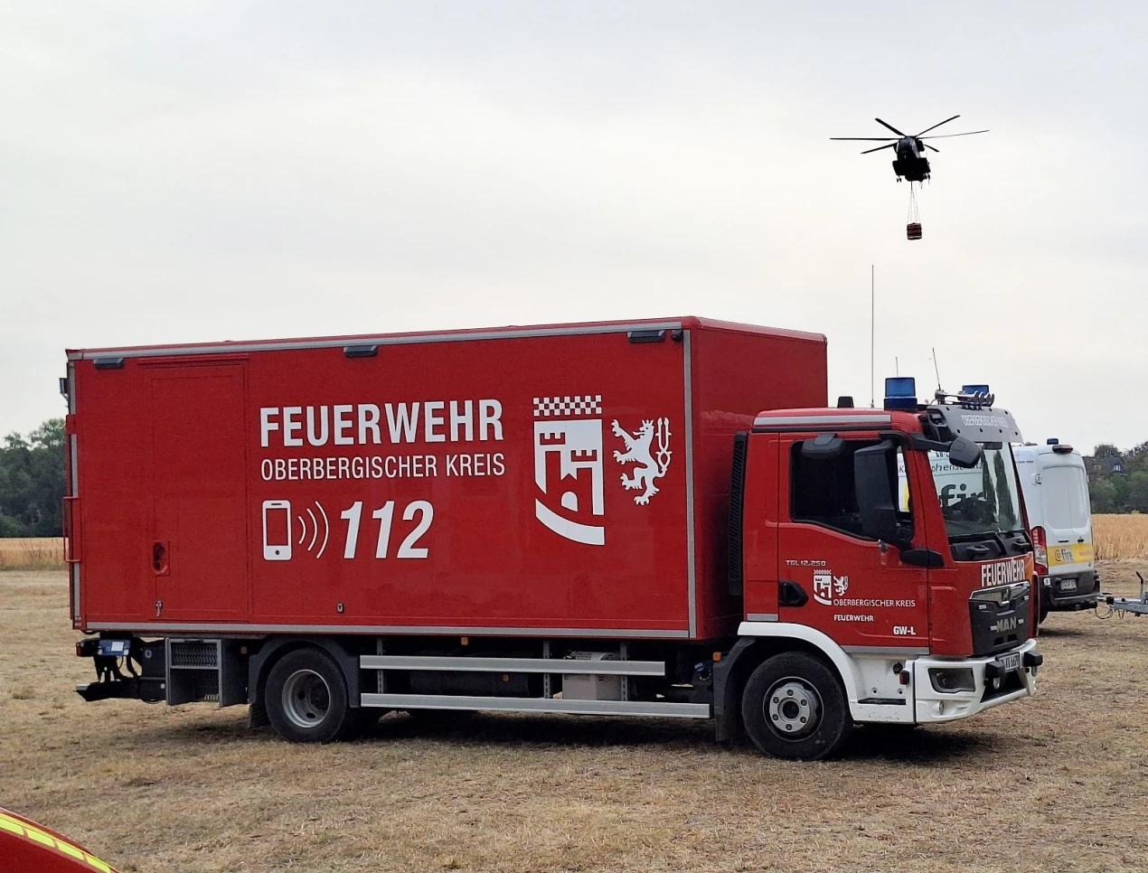 Vor Ort: Logistikfahrzeug des OBK, im Hintergrund ein Helikopter für den Wassertransport. (Foto: OBK)