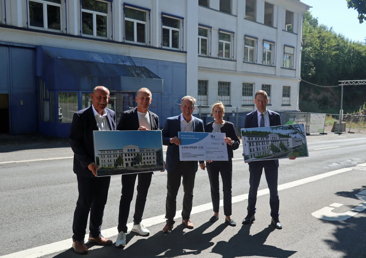 Offizielle Übergabe des Fördermittelbescheids zur Förderung des Wohnprojekts  in der ehemaligen Tapetenfabrik P + S in Gummersbach. Landrat Klaus Grootens (M.) überreicht einen symbolischen Scheck an Julia Leuker, Geschäftsführerin der Kaiser 90 Immobilien GmbH; (v. l.) Kreisbauamtsleiter Michael Starck; Patrick Deyerl, Geschäftsführer der Kaiser 90 Immobilien GmbH und der Bürgermeister der Stadt Gummersbach, Raoul Halding-Hoppenheit, freuen sich, dass dieses Wohnprojekt gemeinsam realisiert werden kann. (Foto: OBK)  
