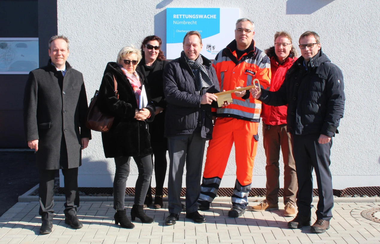 Kreisdirektor Klaus Grootens (v.l.), Gabriele Keil-Riegert(Leiterin Amt für Immobilienwirtschaft), Kirsten-Karina Klein (Amt für Immobilienwirtschaft), Landrat Jochen Hagt, Wachleiter Sebastian Schmidt, Dr. Ralf Mühlenhaus (Leiter Amt für Rettungsdienst, Brand- und Bevölkerungsschutz) und Architekt Jörg Weber bei der Schlüsselübergabe vor der Rettungswache Nümbrecht. (Foto: OBK)