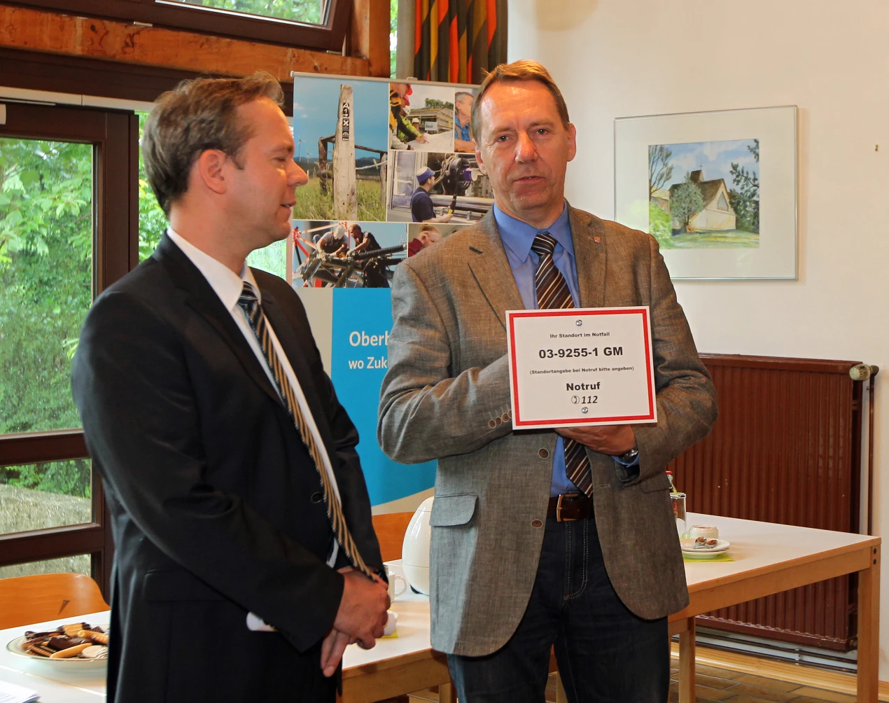 Kreisdirektor Jochen Hagt (r.) und Dezernent Klaus Grootens erklären die Handlungsweise im Notfall: Die "112" wählen und die Nummer auf dem Schild durchgeben. (Foto: OBK)