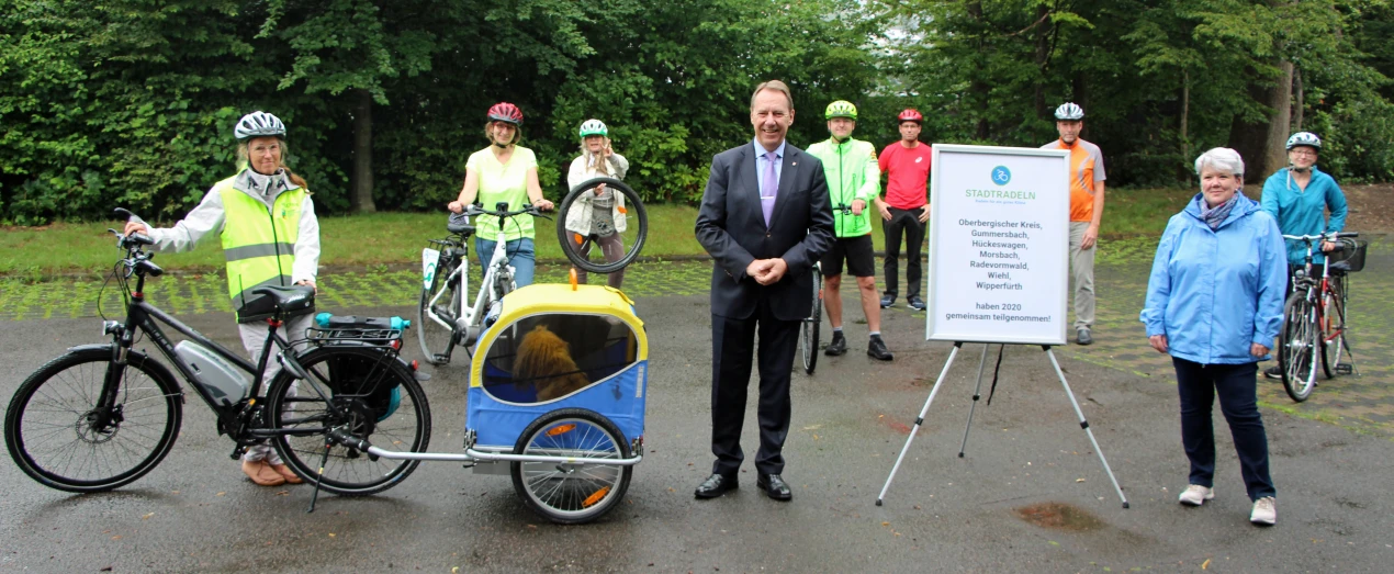 Landrat Jochen Hagt (M.) und Sabine Bremen (r.), Leiterin des Amtes für Planung, Entwicklung und Mobilität, danken allen STADTRADELN-Teilnehmenden für den erfolgreichen Wettbewerb. Die Radlerinnen und Radler stehen hier stellvertretend für die mehr als 1.100 STADTRADELN-Teilnehmende im ganzen Oberbergischen Kreis. (Foto: OBK)