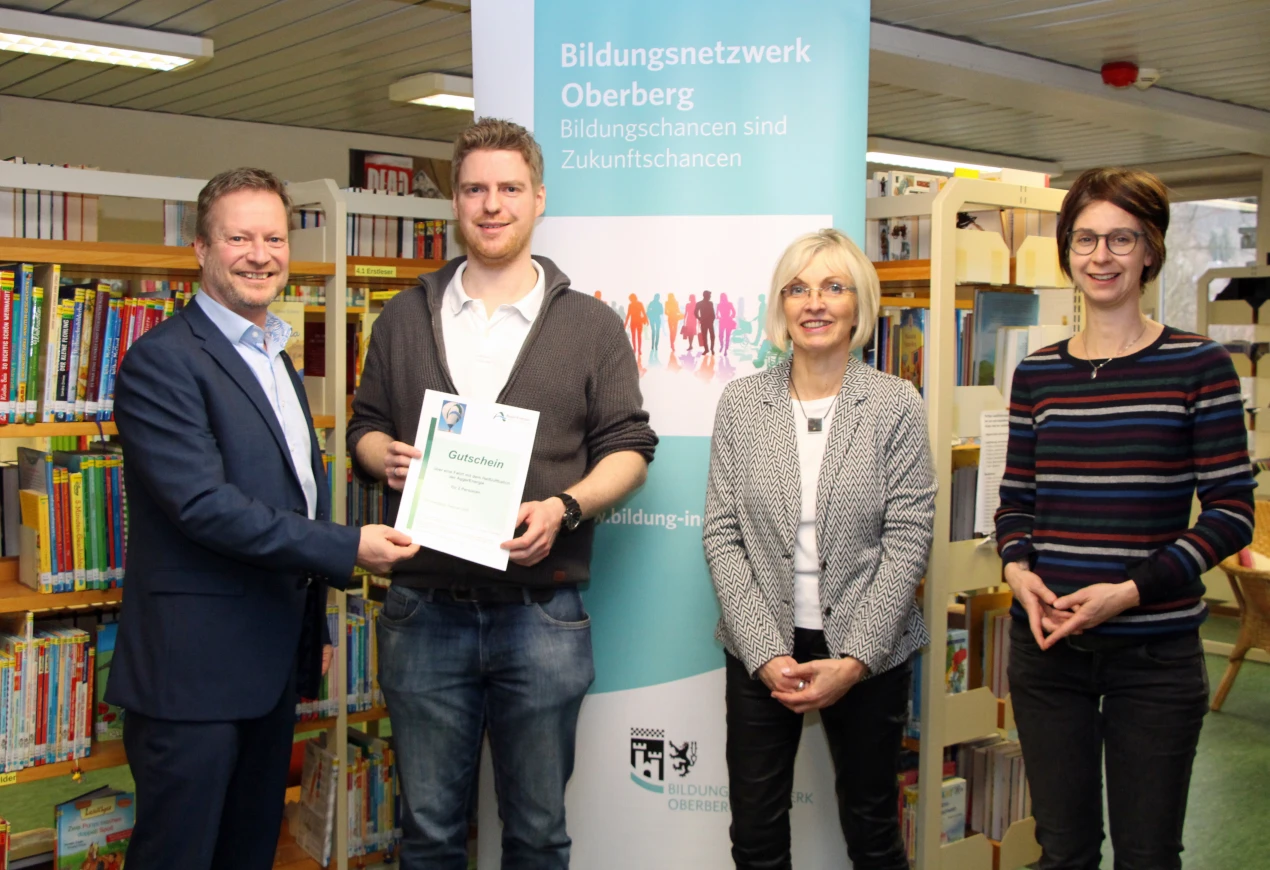 Christian Bürgin, Leiter der Kreis - und Stadtbücherei Gummersbach (2.v.l.) nimmt den Gutschein von Peter Lenz, AggerEnergie entgegen. Anke Koester, Leiterin des Amtes für Schule und Bildung und Ulrike Fink, Bildungsbüro freuen sich über die große Zahl der Akteure am bundesweiten Vorlesetag. (Foto: OBK)  