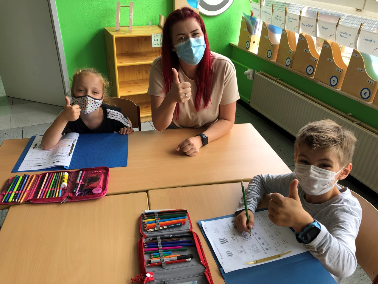 Lehrerin Laura Baroth, die Schülerin Gjermonesha und Schüler Max (Klasse 3) freuen sich darüber, dass das neue Schuljahr mit Präsenzunterricht gestartet ist. (Foto: GGS Wiedenest)
