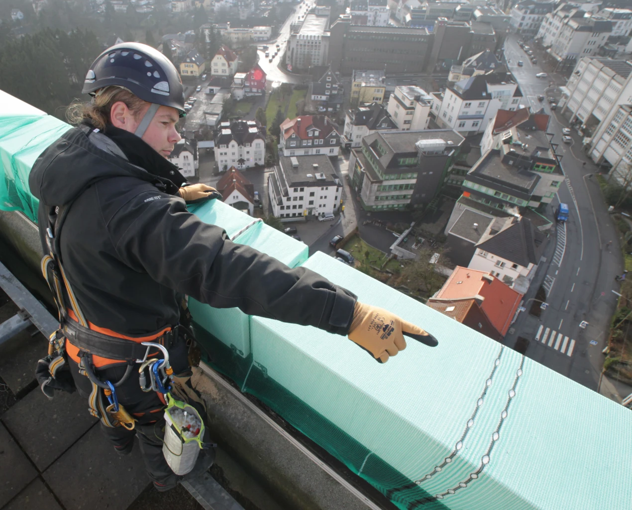 An der Attika des Kreishausdaches wird ein Vlies befestigt: Vorarbeiten für die Installation modernster Abhörschutz-Technik.(Foto:OBK)