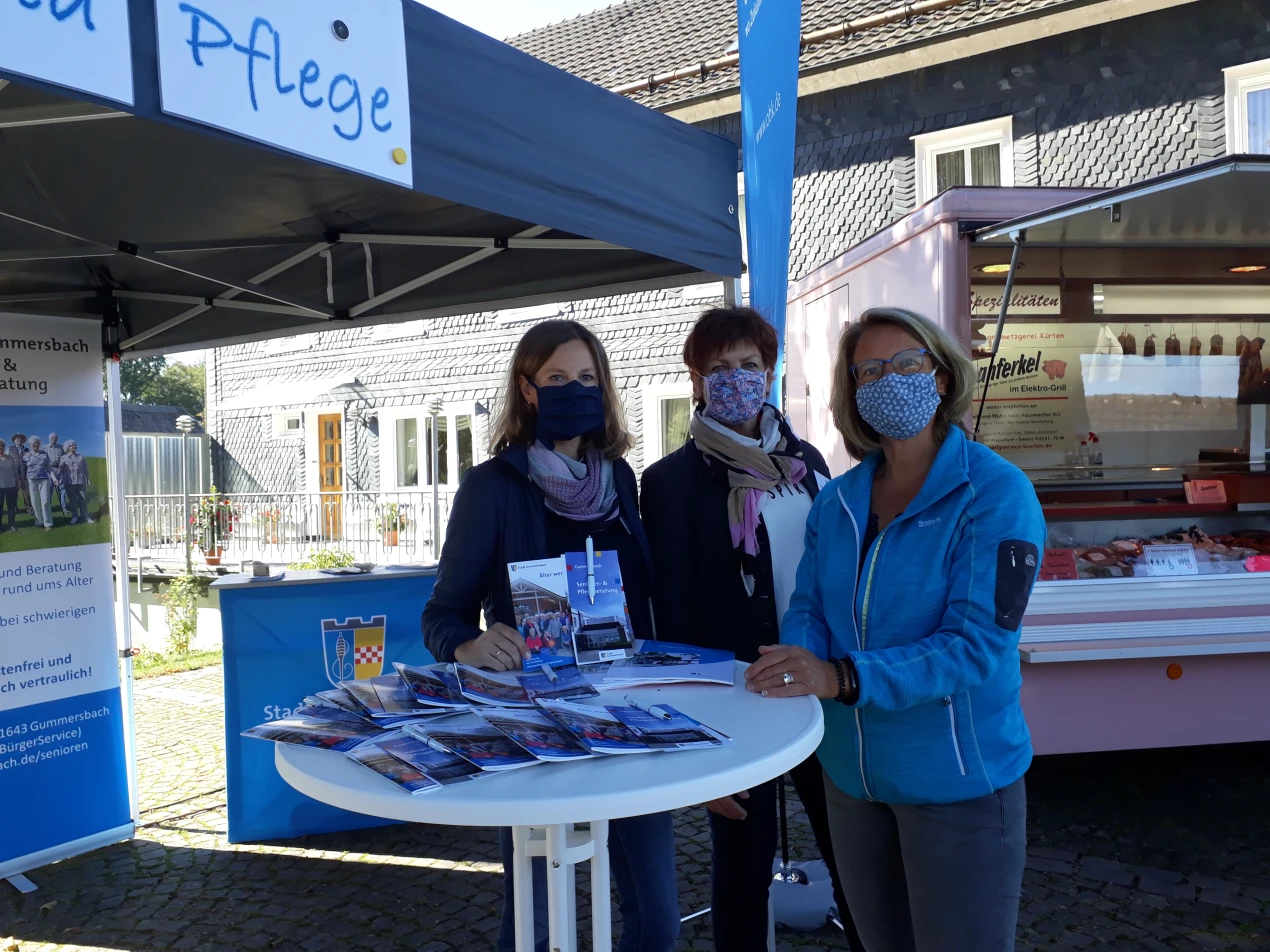 Foto: Jana Steiniger, Corrina Sells, Senioren- und Pflegeberatung der Stadt Gummersbach und Christine Prinz, Koordinatorin der Senioren- und Pflegeberatung für den Oberbergischen Kreis, freuen sich über Zulauf am Infostand auf dem Wochenmarkt in Hülsenbusch. (Foto: OBK)