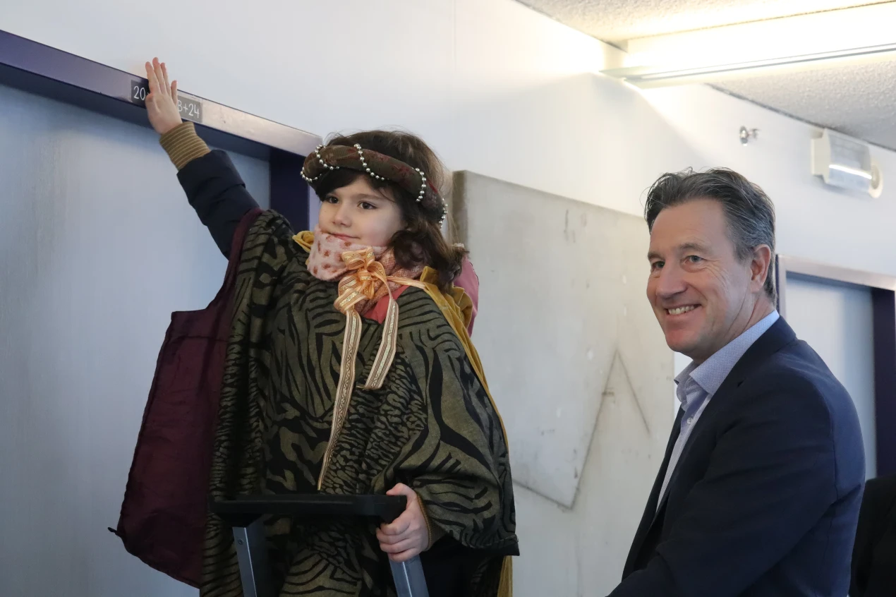 Begleitet von Kreisdezernent Ralf Schmallenbach befestigt Anna den Segensspruch über der Bürotür des Landrates. (Foto: OBK)