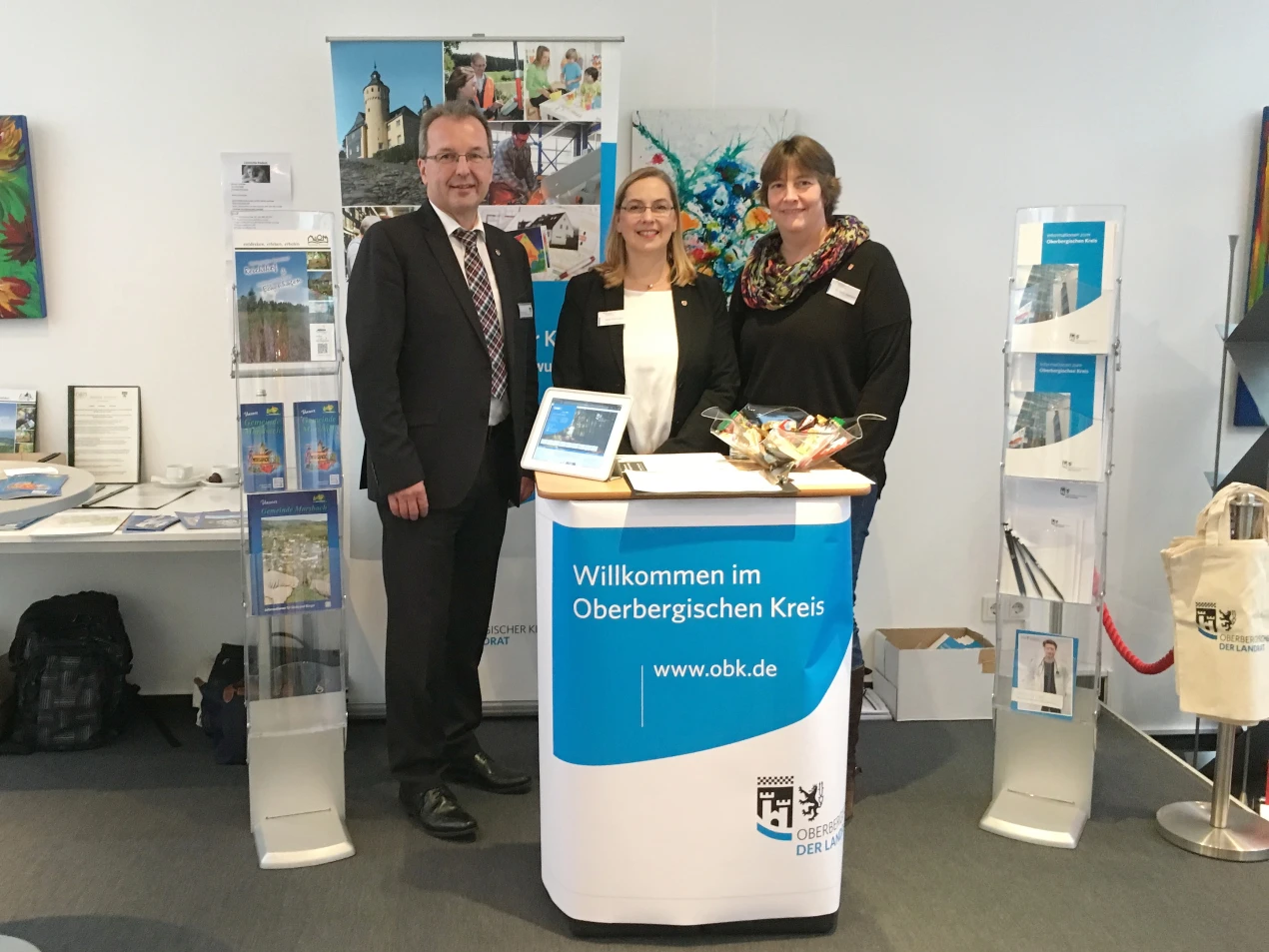 Rüdiger Gennies (Bürgermeister Reichshof), Dr. Kaja Elvermann (Leiterin des Gesundheitsamt Oberbergischer Kreis) und Carla Adelmann (Kinder- und Jugendärztlicher Dienst des Oberbergischen Kreises) am Oberbergischen Stand auf des Praxisbörsentags in Köln. (Foto:  OBK)