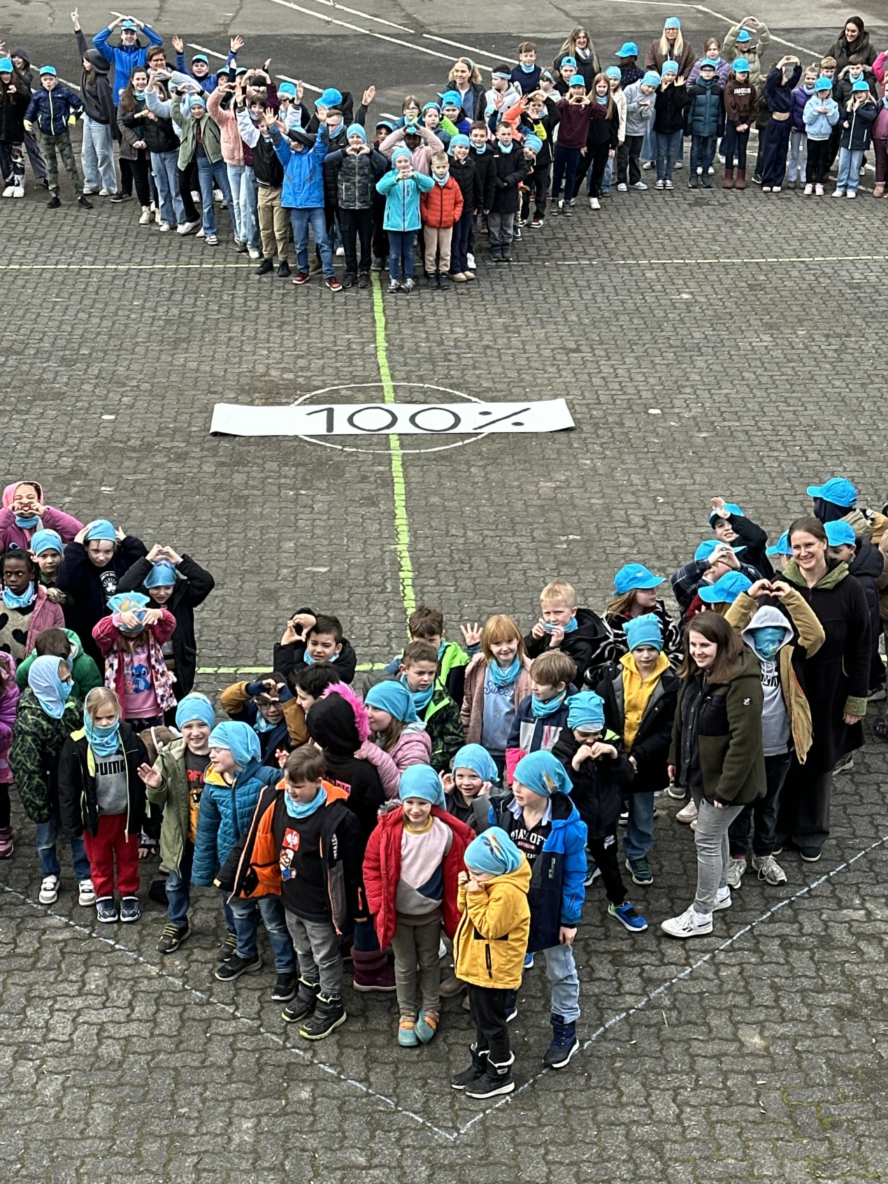 Nachdem die Schülerinnen und Schüler ein Herz auf dem Schulhof gebildet hatten, formten sie mit ihren Händen weitere Herzen als Symbole für Zusammenhalt, Solidarität und Mitmenschlichkeit. (Foto: OBK)  