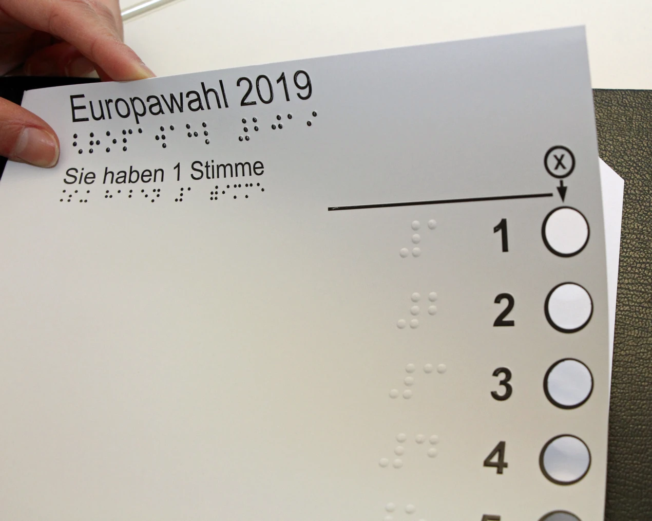 Am Wahltag nimmt der blinde oder sehbehinderte Wähler seine Schablone mit ins Wahllokal und legt dort den Stimmzettel vor der Wahlhandlung in seine Stimmzettelschablone. (Foto: OBK).