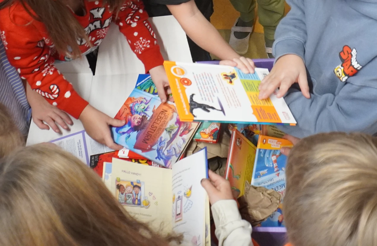 Die Kinder packten die Box begeistert aus und stöberten sofort in den neuen Büchern. (Foto: OBK)