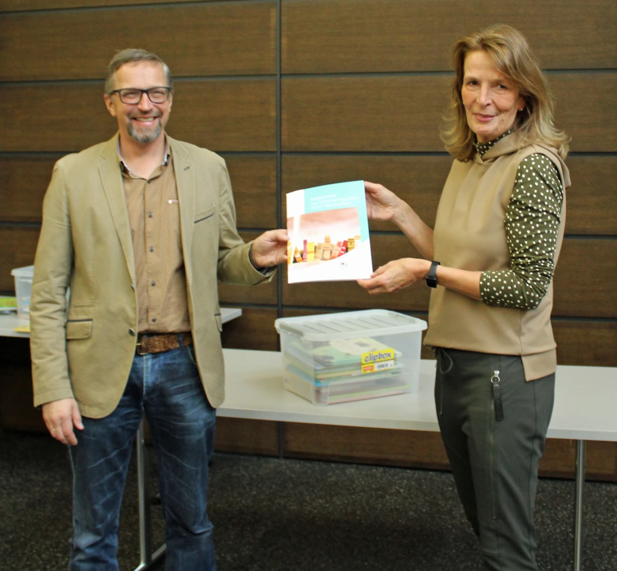 Kerstin Pack, Projektkoordinatorin des Bildungsbüros, übergibt die „Oberbergischen MINT-Bilderbuchboxen“ an Thilo Mücher, Schulleiter des Bergischen Berufskolleg Wipperfürth und Wermelskirchen. (Foto: OBK)