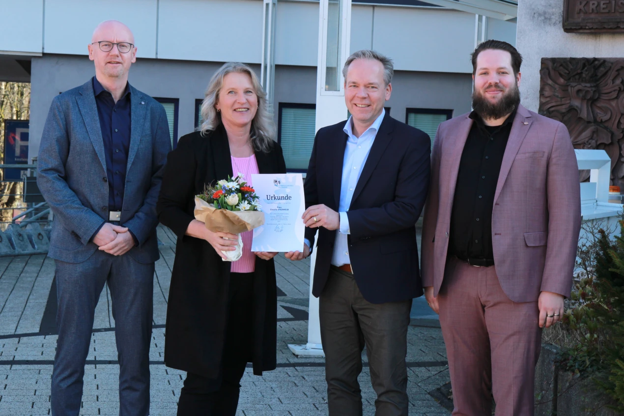 Kreisdirektor Klaus Grootens (M.); Ulrich Welter, Leiter des Personalamtes (l.) und Kevin Kallies, Vors. des Personalrats (r.) gratulieren Claudia Steinhilb. (Foto: OBK)