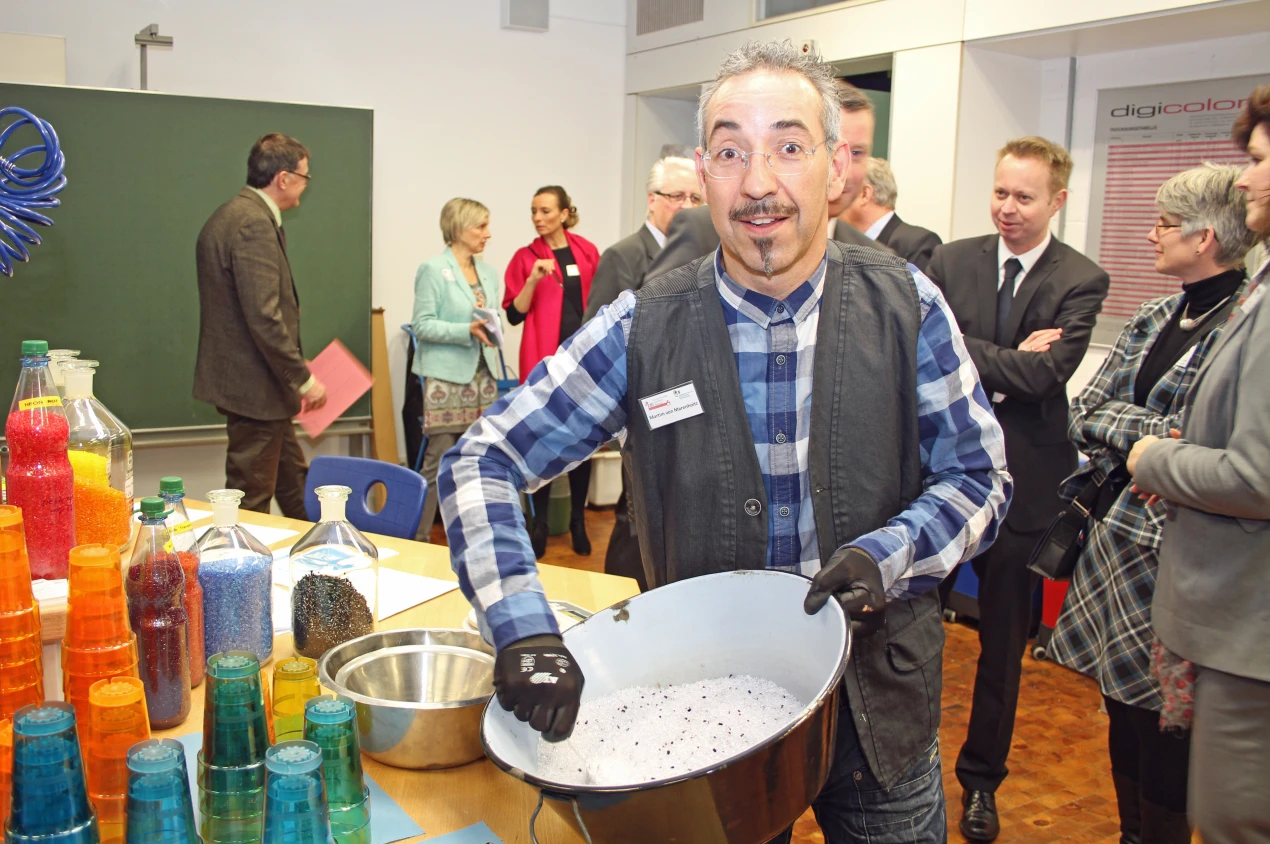 Gleich füllt Martim von Marenholtz die Kügelchen in die imposante Kunststoffspritzgussmaschine im neuen Schülerlabor. Heraus kommt später ein Trinkbecher. (Foto: OBK)