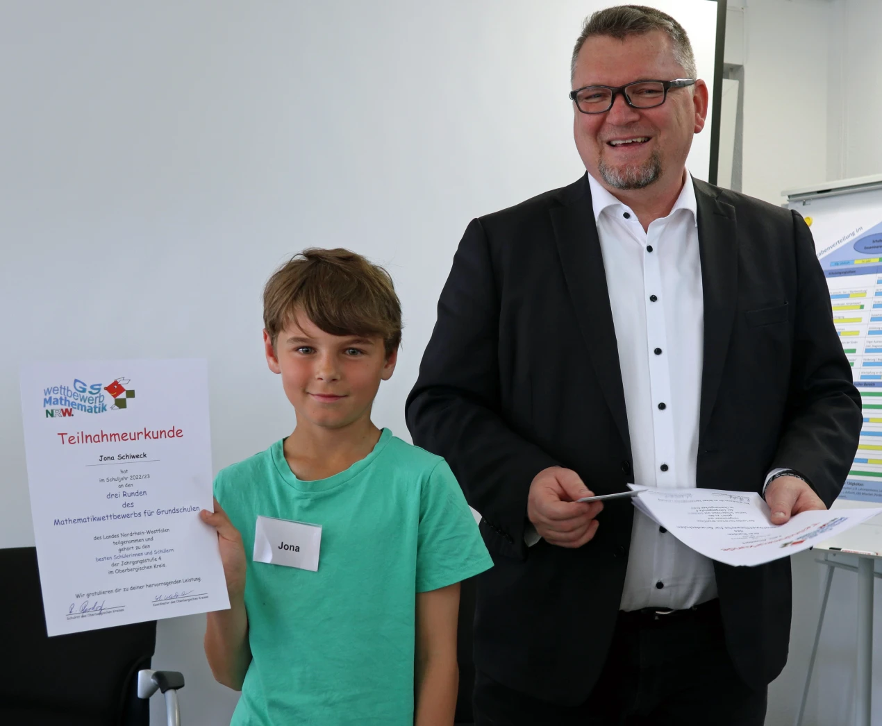 Jona Schiweck aus Wipperfürth zeigt stolz seine Urkunde. Schulrat Reiner Pfesdorf zeichnete die fünf oberbergischen Matheasse aus und überreichte neben den Siegerurkunden auch Familiengutscheine. (Foto:OBK)