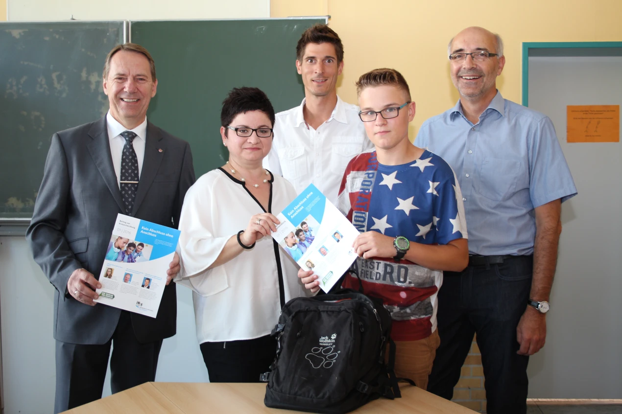 Wie an der Sekundarschule Nümbrecht verteilen die Studien- und Berufswahlkoordinatoren an die 8.-Klässler die Kreisbroschüre  „Kein Abschluss ohne Anschluss“. v. l. Landrat Jochen Hagt, Ismeta Mustafai, Mutter einer Schülerin, Arne Altwicker, Studien- und Berufswahlkoordinator, Schüler Enrico Taratycki, Schulleiter Jürgen Horn