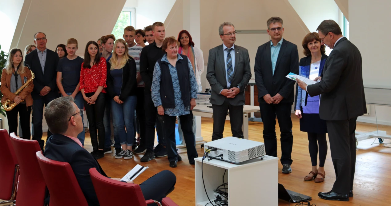 Landrat Jochen Hagt überreicht die Siegelurkunde an die Gesamtschule Reichshof (v.r.n.l.): Landrat Jochen Hagt; Schulleiterin Anne Halfar, Jörg Schmoock, stellvert. Schulleiter; Rüdiger Gennies, Bürgermeister der Gemeinde Reichshof; Mirjam Stieber und Annette Schößler, Koordinatorinnen für Berufs- und Studienorientierung an der Gesamtschule; Schülerinnen und Schüler der Gesamtschule Reichshof und Ralf Ribinski, stellvertretender Schulpflegschaftsvorsitzender (l.). (Foto: OBK)     