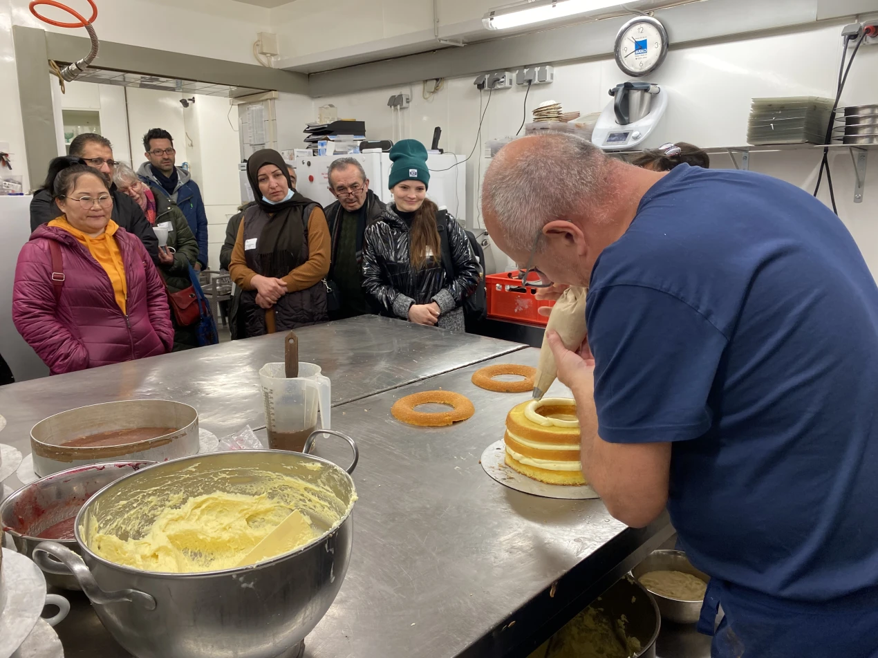 Interessiert ließen sich die Teilnehmerinnen und Teilnehmer in der Backstube des Café Hecker zeigen, wie eine Torte hergestellt wird. (Foto: OBK)
