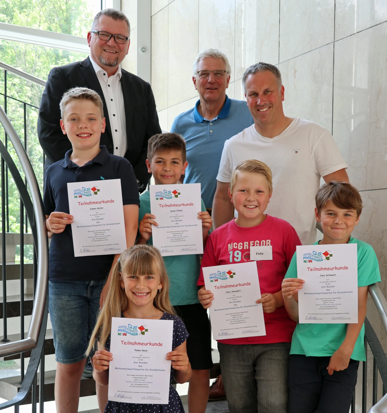 Schulrat Reiner Pfesdorf (l.) und die Schulleiter Stephan Wittkampf (M.) und Matthias Greven freuen sich mit den Siegerkindern (v.l.): Jannes Köster, Polina Novik, Kazim Özmen, Felix Altendorf und Jona Schiweck. (Foto: OBK)  