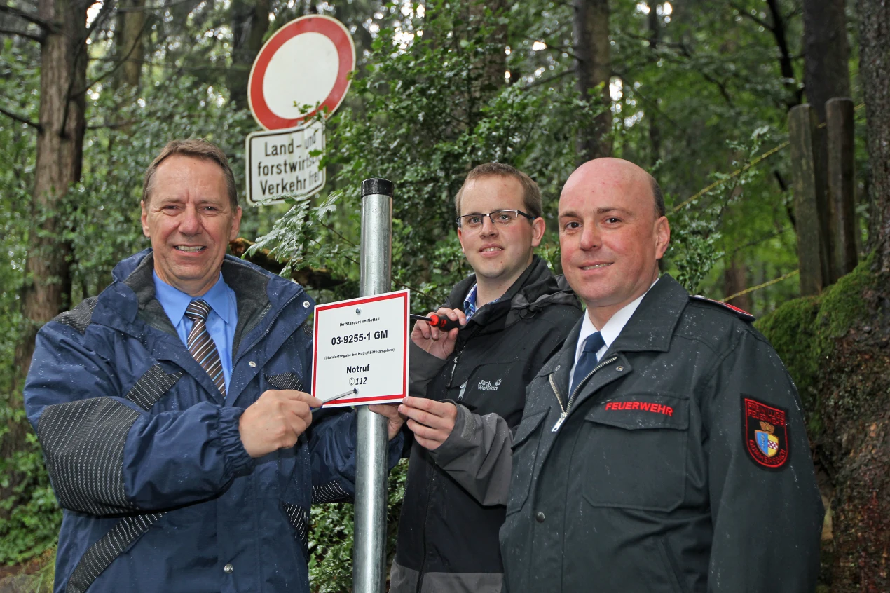 Befestigen einen von 18 Waldrettungspunkten in und um Berghausen: Kreisdirektor Jochen Hagt (l.), Julian Langlotz vom Verschönerungsverein Berghausen (M.) und Christof Kallabis, Einheitsführer der Löschgruppe Berghausen. (Foto: OBK)