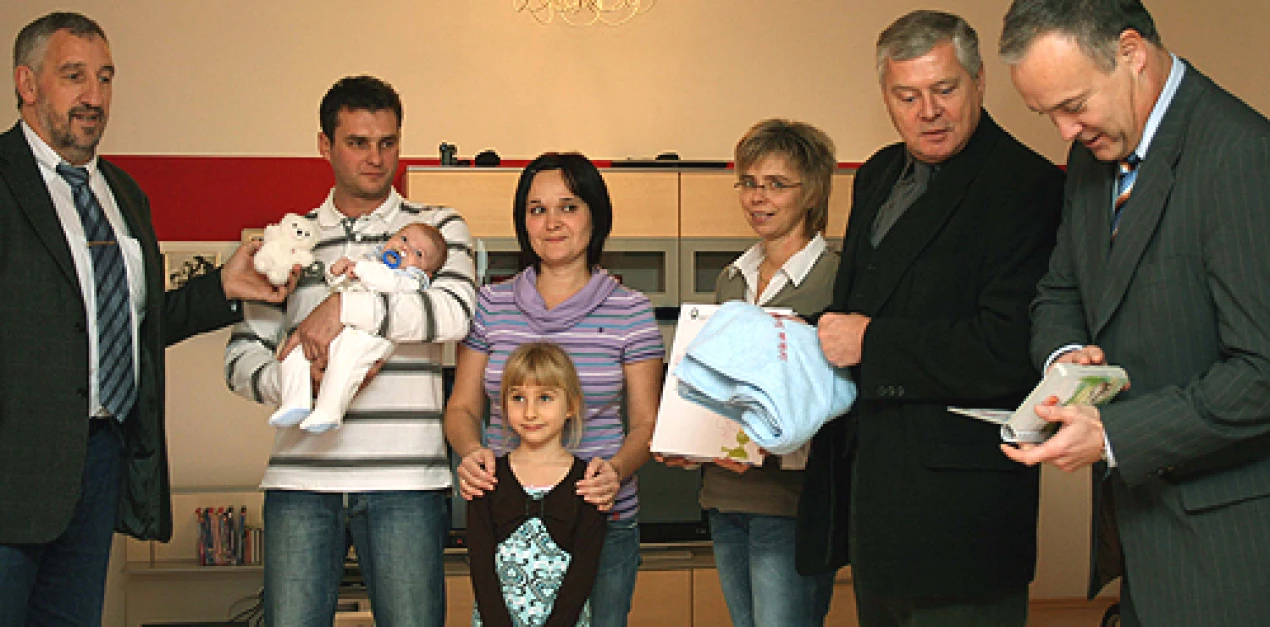 Bürgermeister Koester, Dr. Nürmberger, Nicole Tillmann (v.r.) und Rolf Braun (l.) freuen sich mit Familie Schuldeis über die Geburt des kleinen Jan. (Foto: OBK)