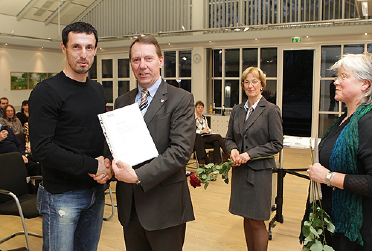 Kreisdirektor Jochen Hagt, Renée Scher und Marianne Dünn von der KVHS gratulieren Goran Stojanovic (Foto: OBK) 