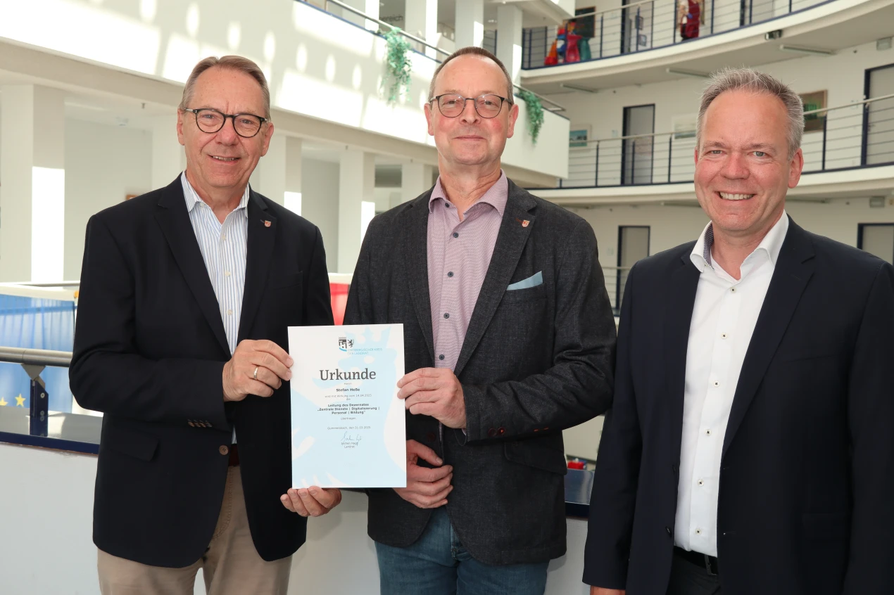 Landrat Jochen Hagt (l.) und Kreisdirektor Klaus Grootens (r.) gratulieren Stefan Heße zu seiner neuen Funktion als Dezernatsleiter für die Bereiche Zentrale Dienste, Digitalisierung, Personal und Bildung. (Foto: OBK)