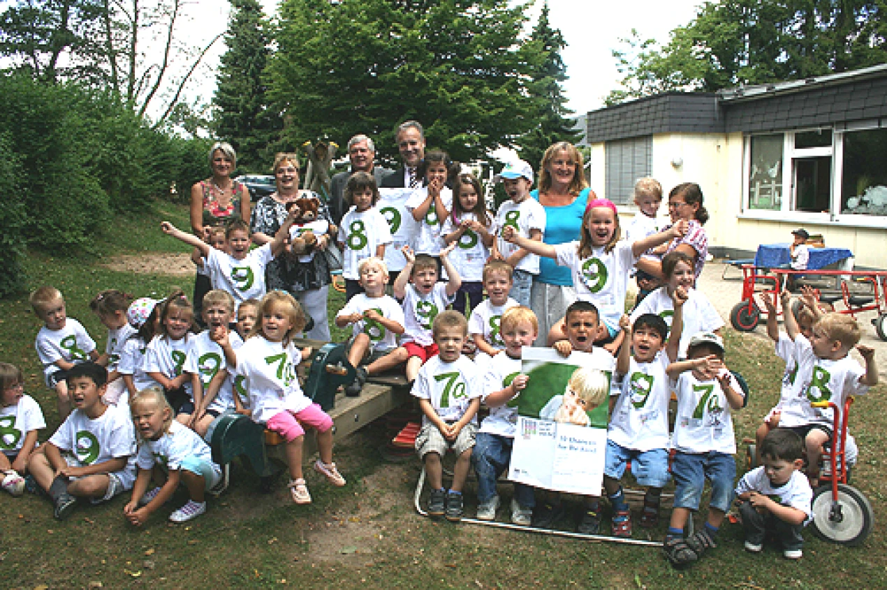 Karin Kohl und Karin Müller vom Jugendamt, Sozialdezernent Dr. Jorg Nürmberger, Bürgermeister Peter Koester und Kindergartenleiterin Ina Hombach (hinten v.l.) freuen sich mit den Kindern über den Sonderpreis. (Foto: OBK)