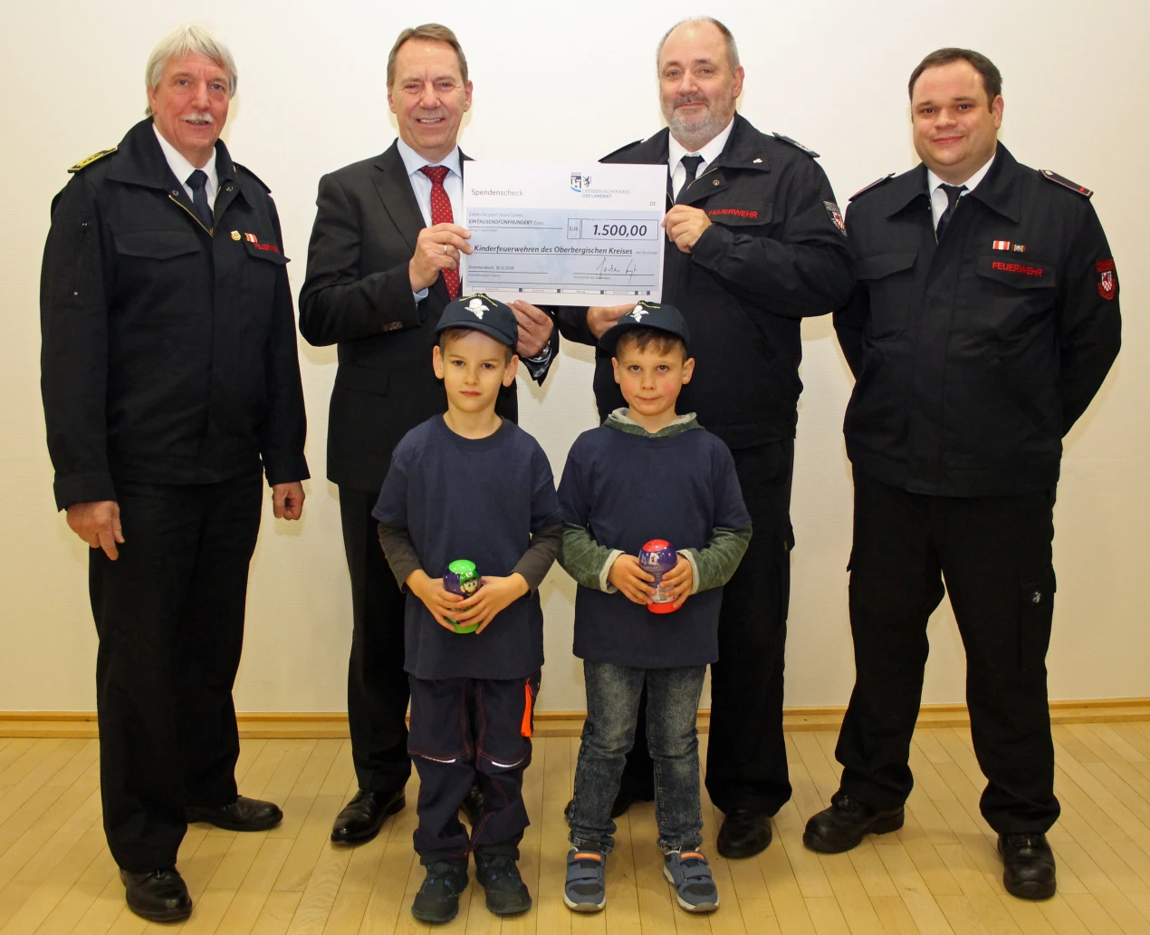 1.500 Euro auch für die Engelskirchener Kinderfeuerwehr (v.l.n.r.): Kreisbrandmeister Wilfried Fischer; Landrat Jochen Hagt; Thomas Krimmel, Leiter der Feuerwehr Engelskirchen; Carsten Metzler, Leiter der Kinderfeuerwehr Engelskirchen und die Feuerwehrjungen Niklas Krutsch und Luis Metzler. (Foto: OBK) 